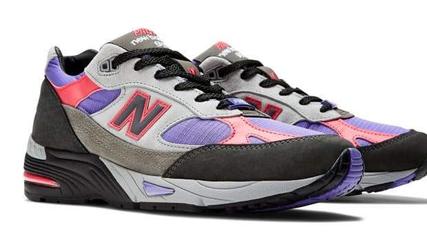 Side view of grey, purple, and black New Balance shoes.